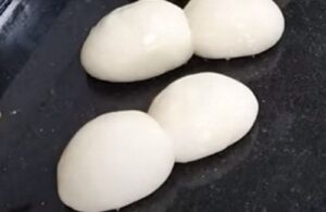 Individual 100 g dough balls (bollos) resting on a floured surface before being joined together.