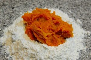 Wheat flour and pumpkin purée A rustic bowl of smooth pumpkin purée next to a sifted mound of wheat flour and melted lard.