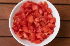 Chooped tomatoes Ripe red tomatoes peeled and chopped into medium-sized cubes, ready for crushing.