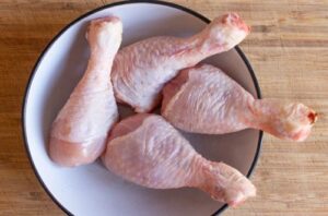 Chicken drumsticks Fresh chicken drumsticks being seared in a large pot until the skin is perfectly crispy and golden brown.