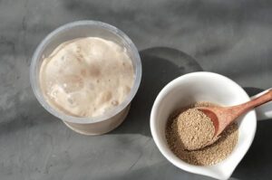 Active yeast mixture foaming in a bowl, ready to be integrated into the flour.