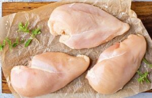 Fresh Chicken A clean, boneless chicken breast being prepared for boiling, representing the lean protein base of the recipe.