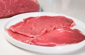 Layered beef Thinly sliced raw beef sirloin strips seasoned and ready for the grill.