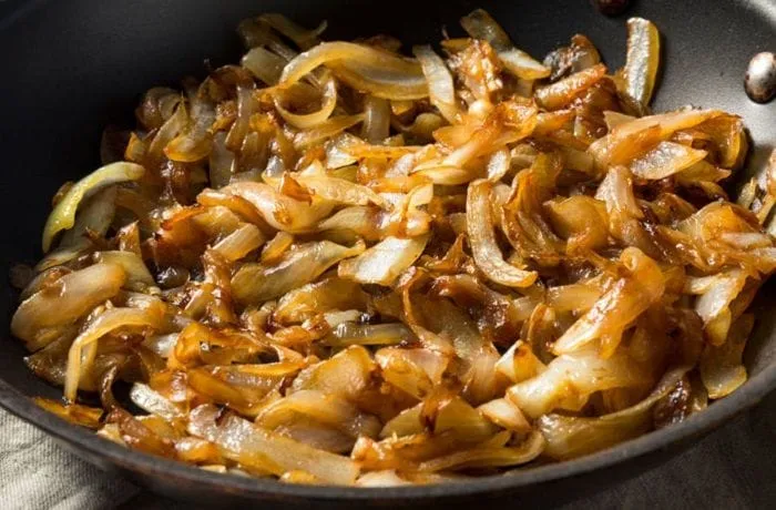 Purple onion caramelized with sugar and soy sauce — the sweet-savory base that is combined with shredded charqui for the canapé topping