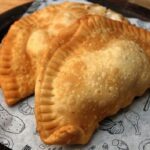 Chilean abalone empanadas (empanadas de locos) — fried and baked versions on a wooden board