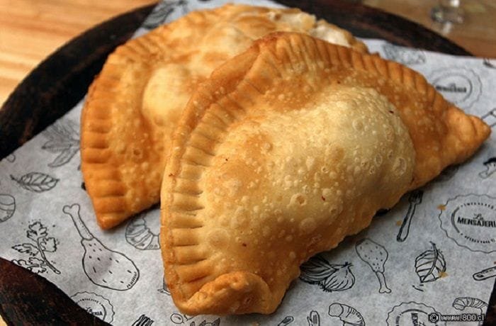 Chilean abalone empanadas (empanadas de locos) — fried and baked versions on a wooden board