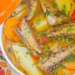 Chilean caldillo de jurel en tarro — canned jack mackerel fish stew with potatoes, carrots, and white wine served hot