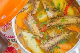 Chilean caldillo de jurel en tarro — canned jack mackerel fish stew with potatoes, carrots, and white wine served hot