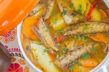 Chilean caldillo de jurel en tarro — canned jack mackerel fish stew with potatoes, carrots, and white wine served hot