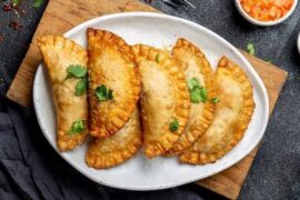 Chilean fried empanadas de jurel en tarro — golden crispy dough filled with canned jack mackerel and hard-boiled egg