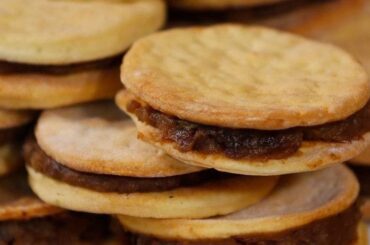 Chilean chancaca alfajores — traditional hojarasca cookies filled with chancaca, walnuts and raisins