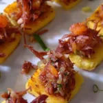 Chilean charqui canapés — toasted bread rounds topped with shredded dried beef, caramelized onion, soy sauce, and merkén