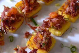 Chilean charqui canapés — toasted bread rounds topped with shredded dried beef, caramelized onion, soy sauce, and merkén