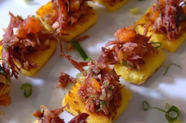 Chilean charqui canapés — toasted bread rounds topped with shredded dried beef, caramelized onion, soy sauce, and merkén