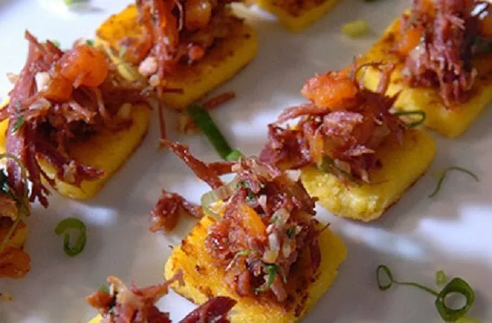 Chilean charqui canapés — toasted bread rounds topped with shredded dried beef, caramelized onion, soy sauce, and merkén