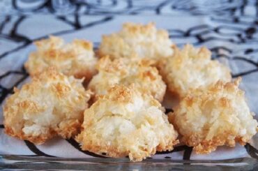 Golden Chilean cocadas with a crispy shredded coconut crust on a baking sheet lined with parchment paper