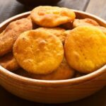 Golden Chilean gluten-free sopaipillas made with rice flour and squash, served on a wooden board