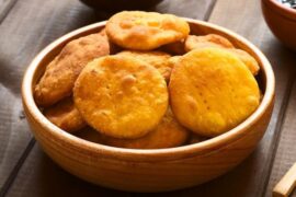 Golden Chilean gluten-free sopaipillas made with rice flour and squash, served on a wooden board