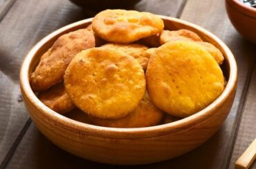 Golden Chilean gluten-free sopaipillas made with rice flour and squash, served on a wooden board