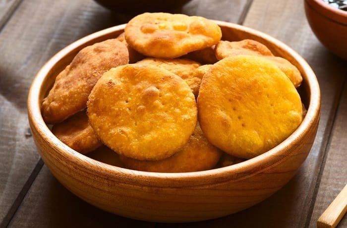 Golden Chilean gluten-free sopaipillas made with rice flour and squash, served on a wooden board