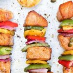 Chilean salmon skewers (brochetas de salmón) with tri-color bell peppers and red onion on a platter