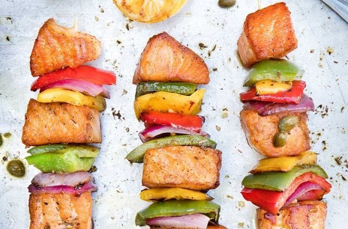 Chilean Salmon Skewers — Brochetas de Salmón Chilean salmon skewers (brochetas de salmón) with tri-color bell peppers and red onion on a platter