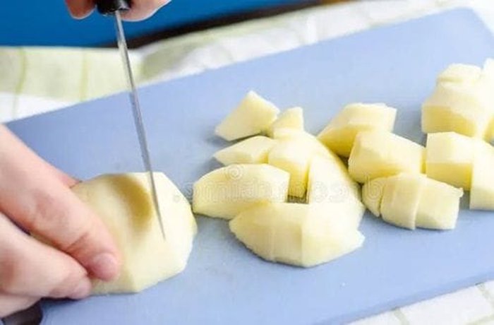 Green apples diced into small cubes, ready to cook the sweet empanada filling.