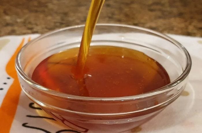 Golden liquid caramel just poured into a glass dish for the macho ruso pudding base