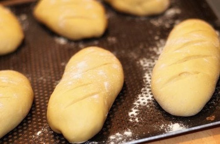 Shaped Pan de Leche Rolls Before Baking Shaped torpedo pan de leche rolls resting on a baking tray before the second proof and baking