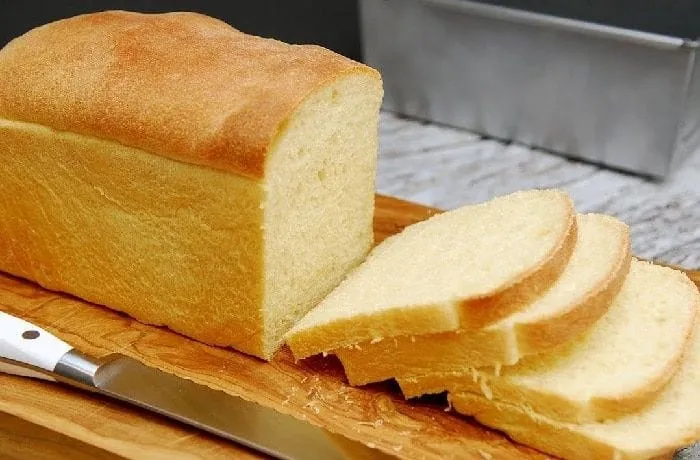 White sandwich bread slices cut into rounds for Chilean charqui canapés — brushed with merkén butter and toasted at 180°C