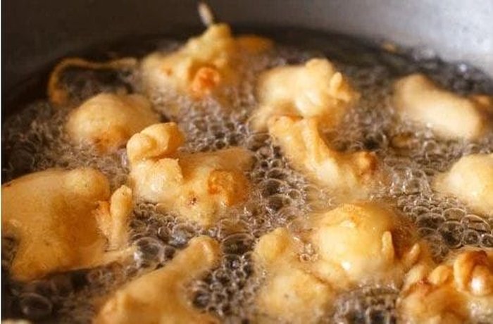 Cauliflower florets coated in batter, ready to fry