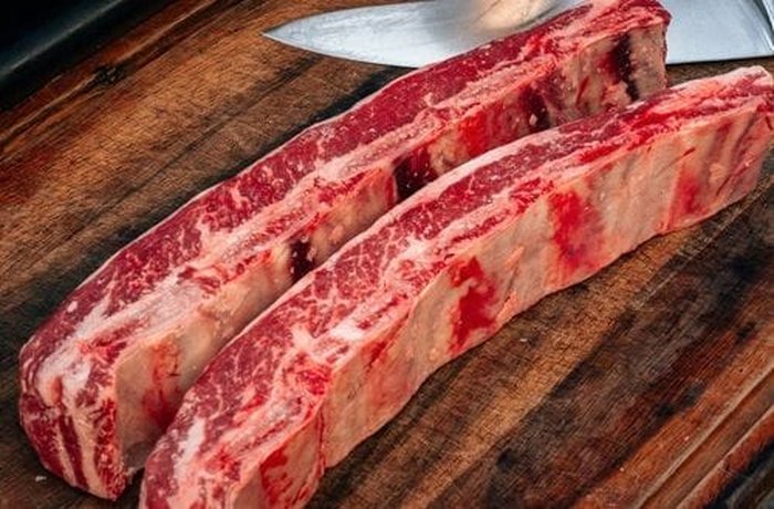 Beef short ribs searing in a hot cast iron pot