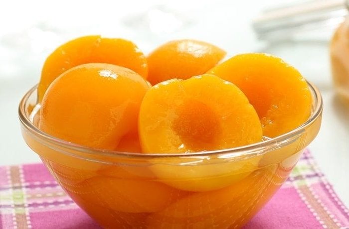 Canned peaches cut into slices, ready to arrange over the kuchen base