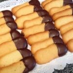 Thin cat tongue cookies with one end dipped in dark chocolate