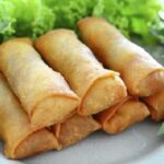Fried Chilean arrollados de jamon y queso, served on a plate.