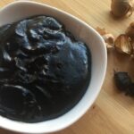 Creamy dark Chilote black garlic sauce in a bowl with parsley