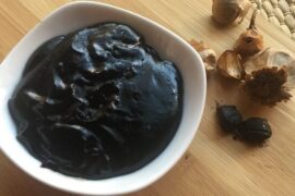 Creamy dark Chilote black garlic sauce in a bowl with parsley