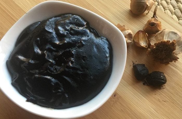 Creamy dark Chilote black garlic sauce in a bowl with parsley