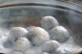 Chilean bolitas de indio, small potato dumplings served cold in sweet spiced milk in a dessert bowl