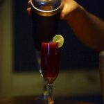 Calafate sour served in glasses with foam, decorated with calafate berries.