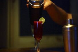 Calafate sour served in glasses with foam, decorated with calafate berries.