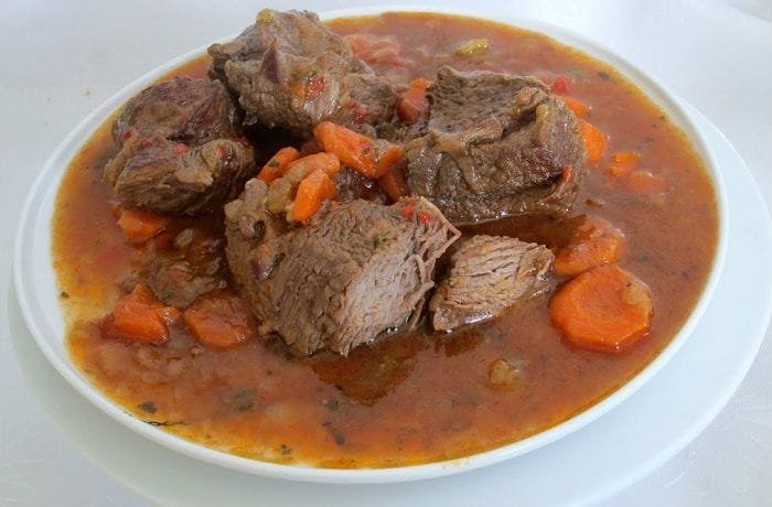 Chilean carne al jugo, tender beef pieces in a thick savory sauce served in a deep plate