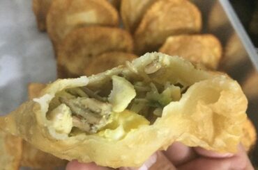Golden, crispy Chilean changles wild mushroom empanadas arranged on a wooden table.