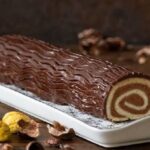 Decorated chestnut and chocolate log served in slices on a Christmas dessert table