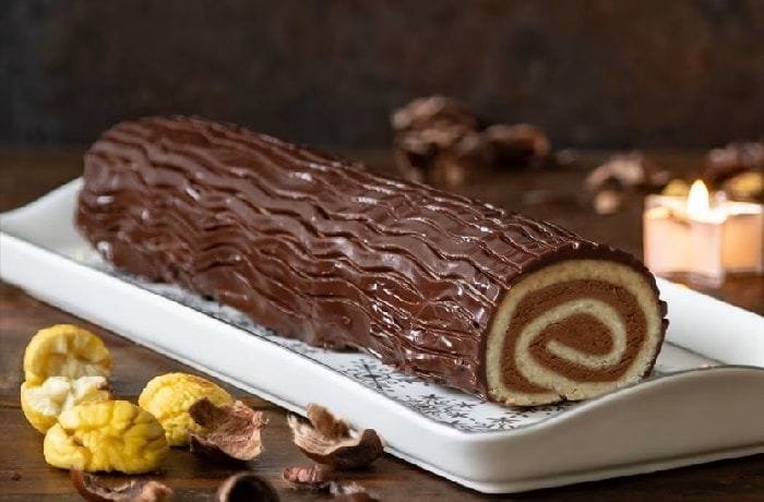 Decorated chestnut and chocolate log served in slices on a Christmas dessert table