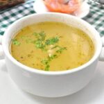 Chilean chicken consomme with egg ribbons and parsley in a bowl