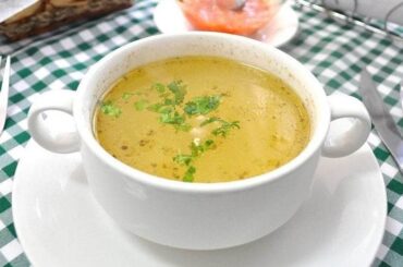 Chilean chicken consomme with egg ribbons and parsley in a bowl