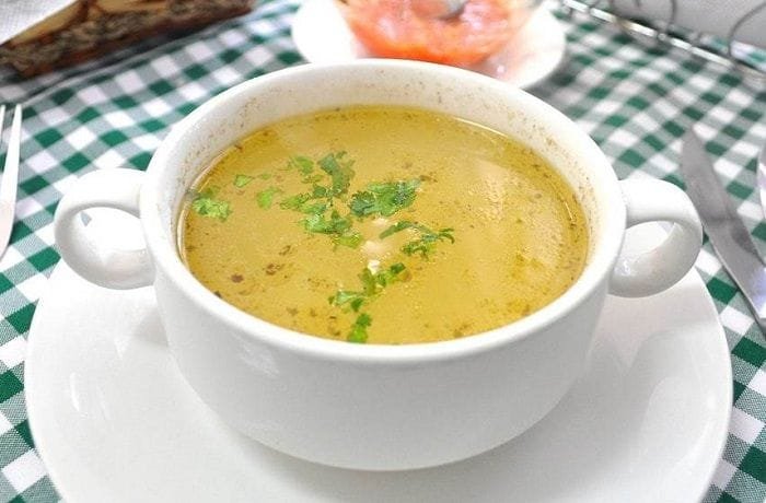 Chilean chicken consomme with egg ribbons and parsley in a bowl