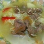 Chilean chicken gizzard soup with vegetables and noodles, served in a bowl.
