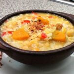 Chilean chickpeas with rice and squash in a clay bowl with merken
